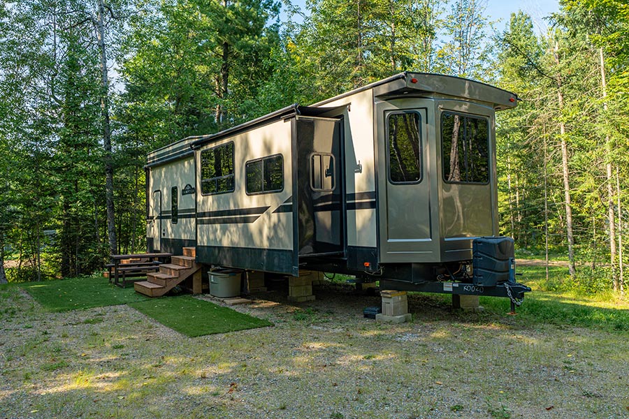 Large rig RV seasonal camping amongst nature and trees at Cabin O' Pines Resort & Campground